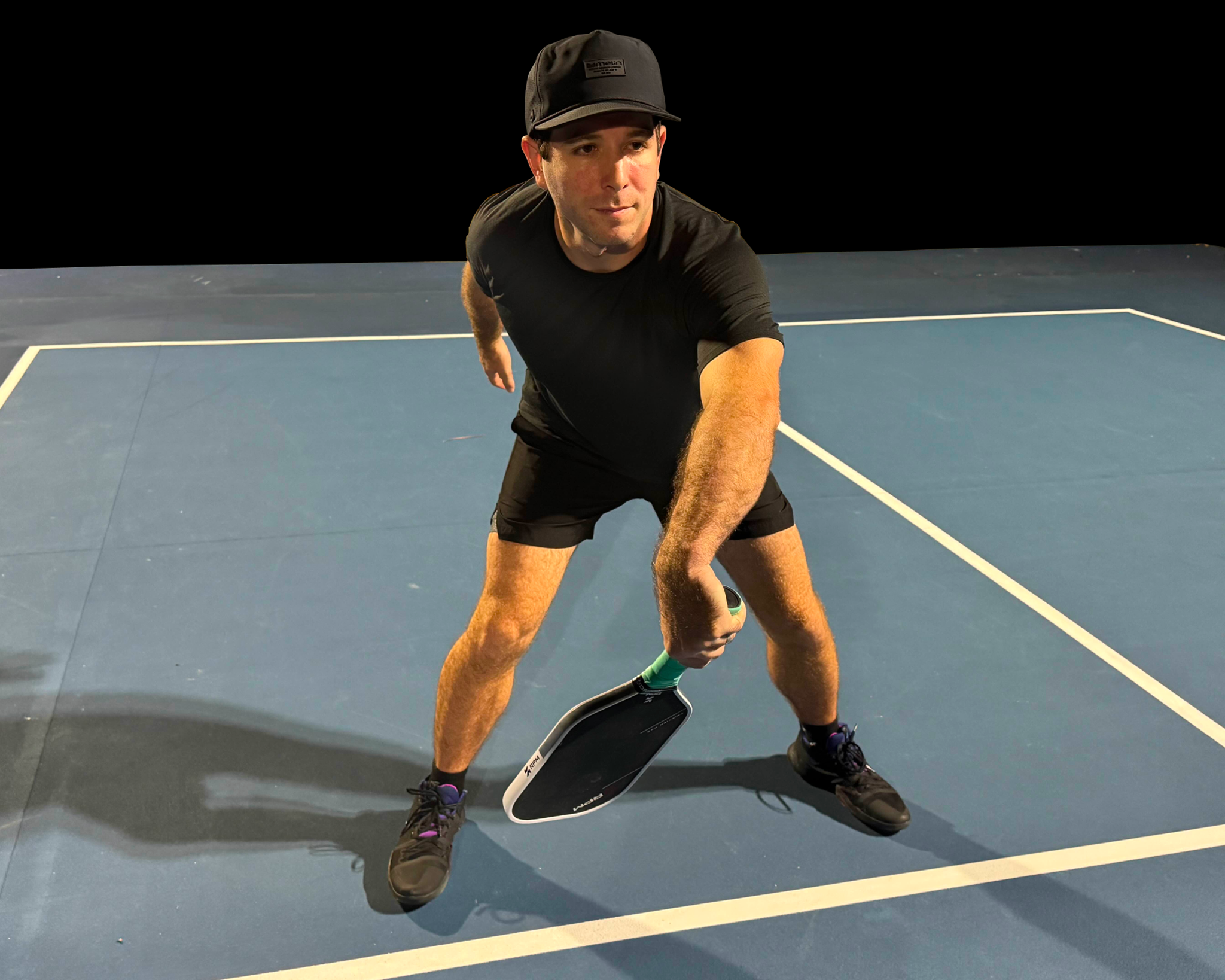 A male pickleball player in action, mid-swing.