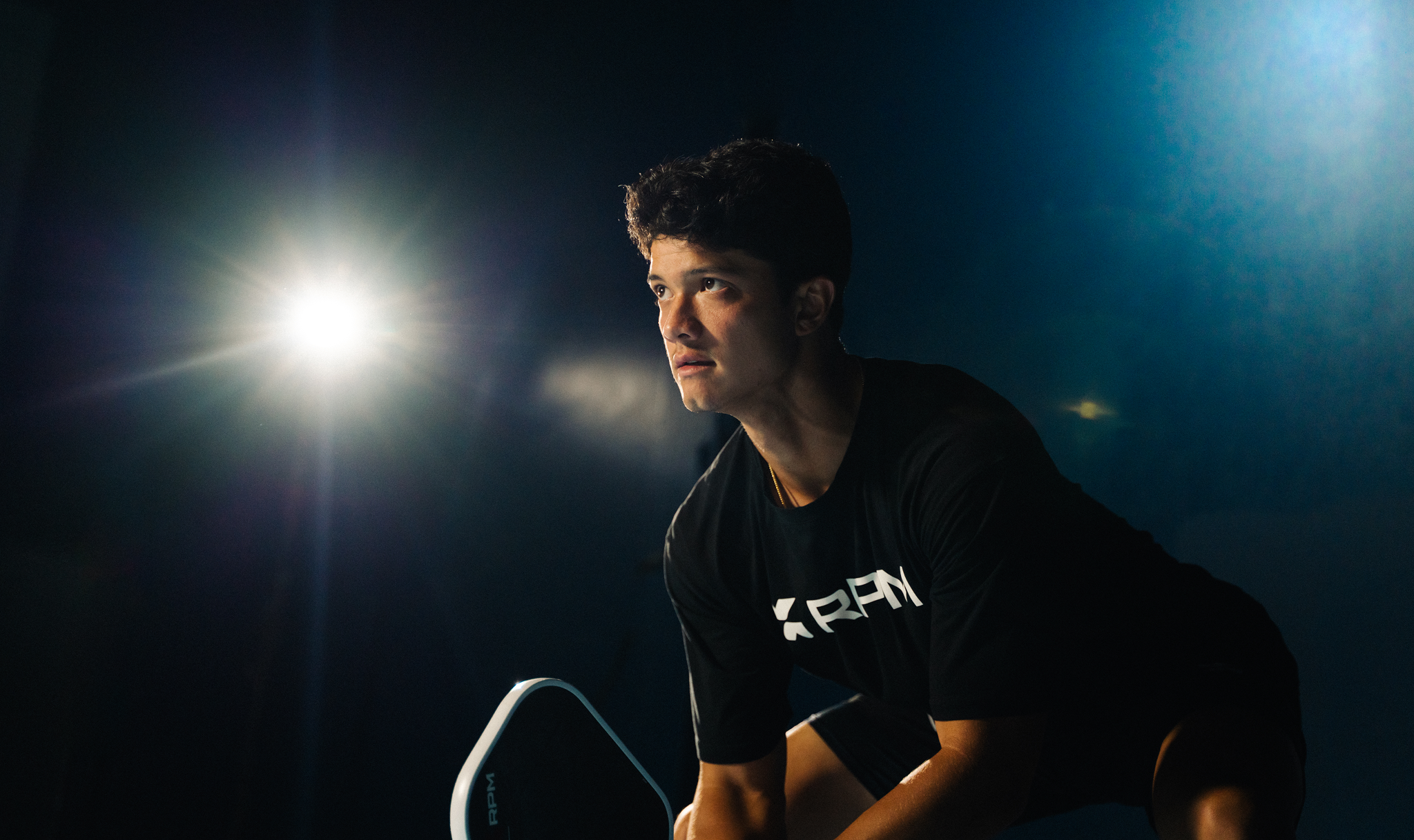 A male pickleball player in action, mid-swing.